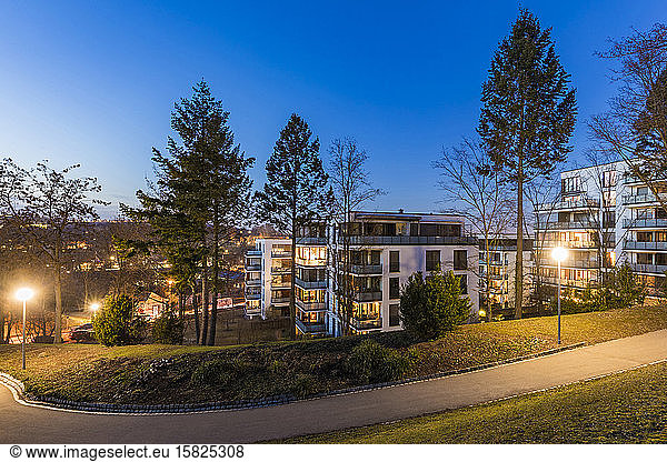 Germany  Baden-Wurttemberg  Stuttgart  Empty footpath in public park at dusk with modern apartments in background