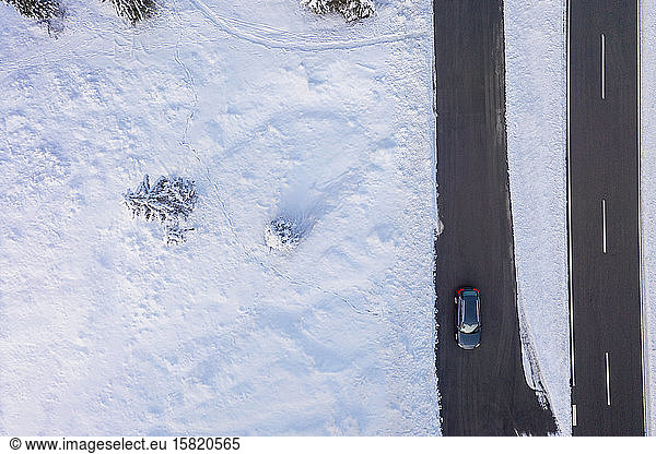 Germany Bavaria Aerial view of car driving along country road in winter