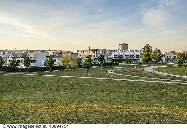 Germany  Bavaria  Augsburg  Grassy area in front of new modern suburban flats at dusk