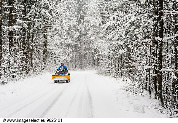Germany  Bavaria  Berchtesgadener Land  man on quadbike in winter landscape