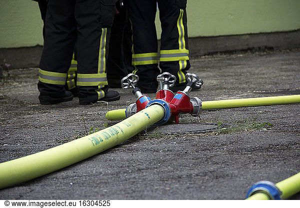 Germany  Bavaria  Firehose with valve  Firefighters in the background