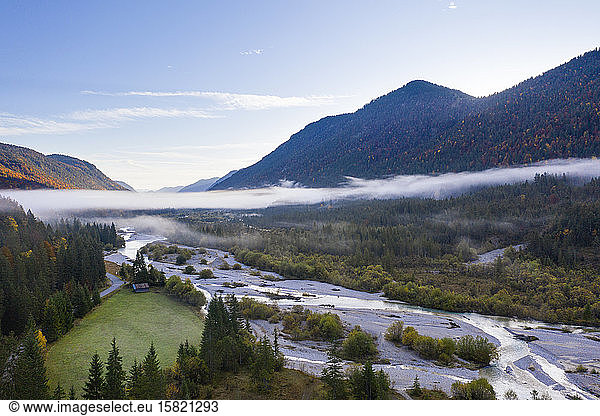 Germany Bavaria Fog floating over Isar river flowing through forested valley in Wetterstein Mountains