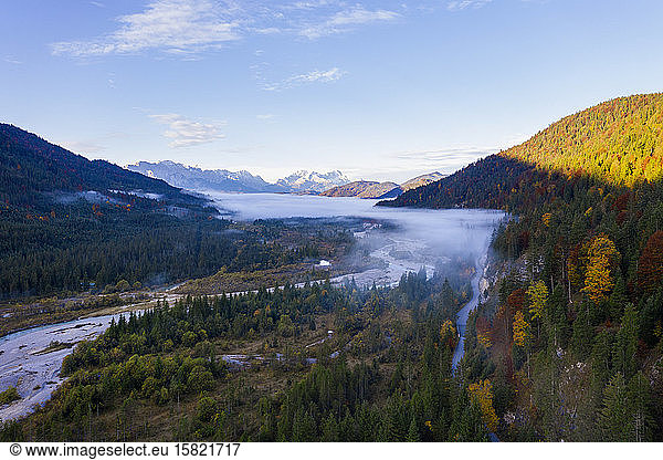 Germany  Bavaria  Fog floating over Isar river flowing through forested valley in Wetterstein Mountains
