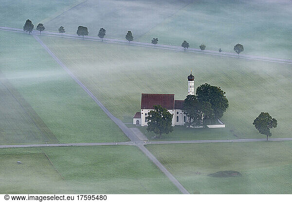 Germany  Bavaria  Fussen  Aerial view of Church of St. Coloman on foggy morning