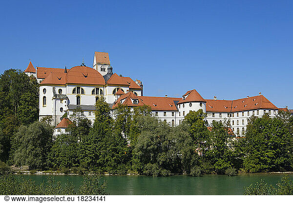 Germany  Bavaria  Fussen  Fussen Castle and St. Mangs Abbey with bank of Lech river in foreground