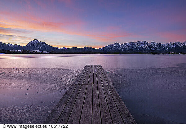 Germany  Bavaria  Fussen  Jetty on shore of Hopfensee lake at winter dawn