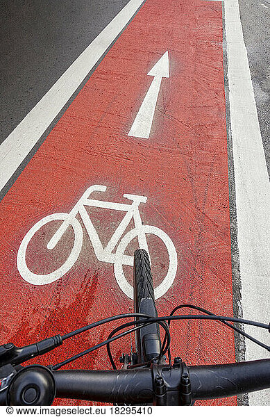Germany  Bavaria  Munich  Bicycle moving along red bicycle lane