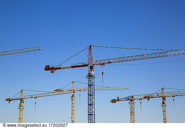 Germany  Bavaria  Munich  Construction cranes against blue sky