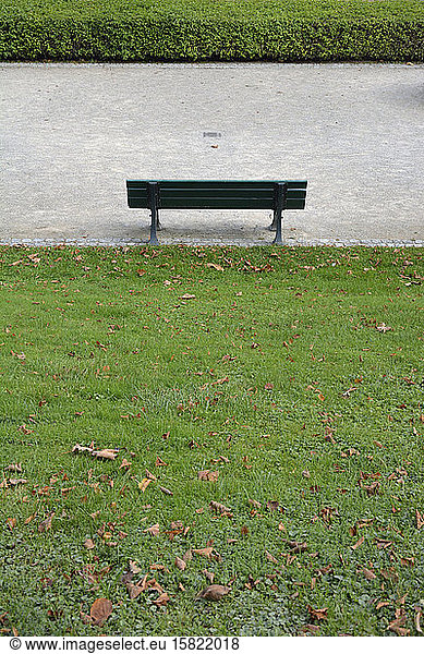 Germany  Bavaria  Munich  Empty park bench standing in front of hedge