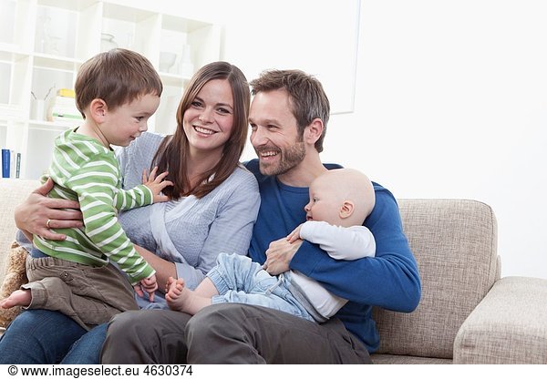 Germany  Bavaria  Munich  Family having fun in living room  smiling
