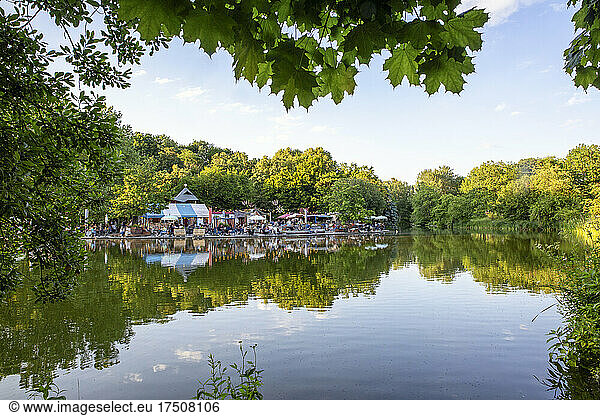 Germany  Bavaria  Munich  Mollsee lake in Westpark with beer garden in background