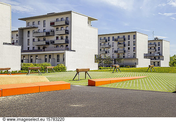 Germany  Bavaria  Munich  Playground with gymnastics vaults in front of residential buildings in Theresienpark