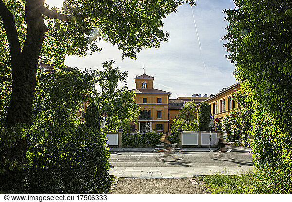 Germany  Bavaria  Munich  Two cyclists passing Lenbachhaus museum