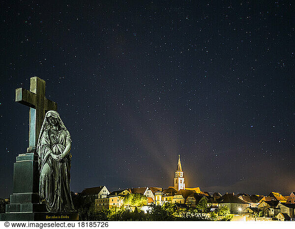 Germany  Bavaria  Nabburg  Tombstone at night with illuminated town in background