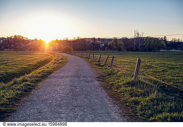 Germany  Bavaria  Neusaess  Countryside dirt road at sunset