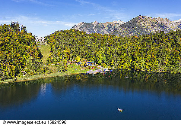 Germany  Bavaria  Oberstdorf  Drone view of forested shore of Freibergsee lake in autumn