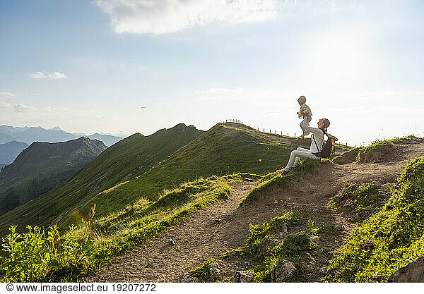 Germany  Bavaria  Oberstdorf  mother and little daughter on a hike in the mountains having a break