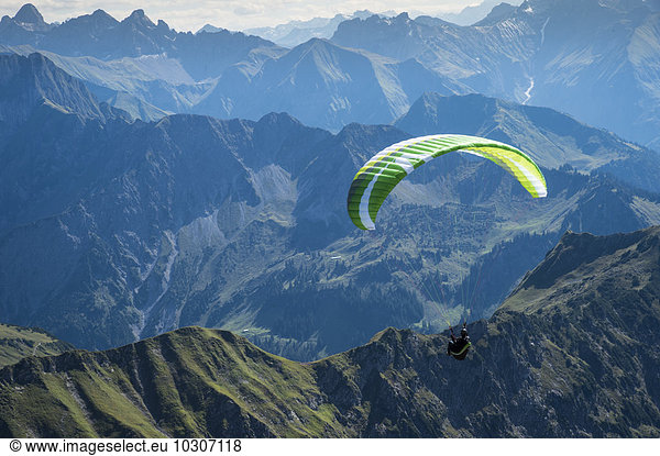 Germany  Bavaria  Oberstdorf  paraglider flying from Nebelhorn to the valley
