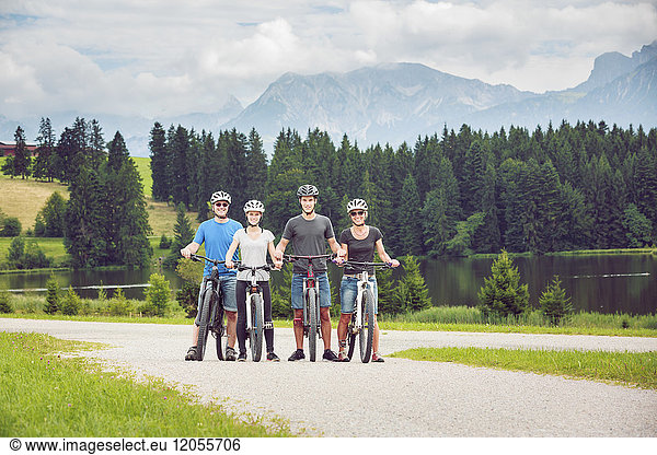 Germany  Bavaria  Pfronten  portrait of happy family with mountain bikes at ladeside