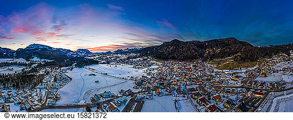 Germany  Bavaria  Reit im Winkl  Helicopter view of snow-covered mountain village at dawn