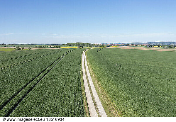 Germany  Bavaria  Rothenburg ob der Tauber  Aerial view of dirt road stretching through green fields in summer