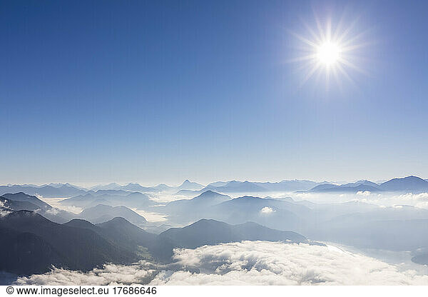 Germany  Bavaria  Summer sun shining over peaks of Bavarian Prealps shrouded in thick fog