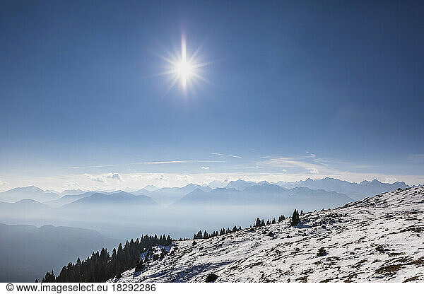 Germany  Bavaria  Sun shining over Ester Mountains shrouded in fog