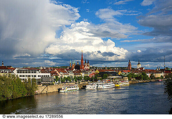 Germany  Bavaria  Wurzburg  Large clouds over riverside city