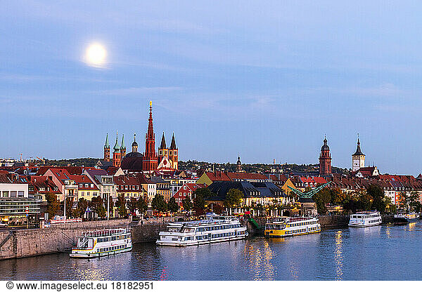 Germany  Bavaria  Wurzburg  Moon glowing over river Main with Wurzburg Cathedral and Marienkapelle in background