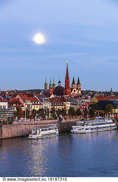 Germany  Bavaria  Wurzburg  Moon glowing over river Main with Wurzburg Cathedral and Marienkapelle in background