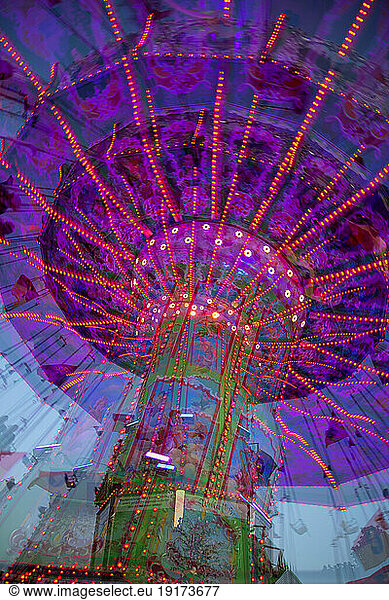 Germany  Bavaria  Wurzburg  Multiple exposure of spinning carousel at dusk