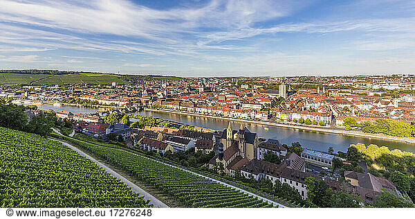 Germany  Bavaria  Wurzburg  Panorama of vineyard and houses of riverside city at dusk