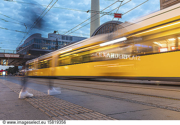 Germany  Berlin  Blurred motion of tram passing through Alexanderplatz at dusk