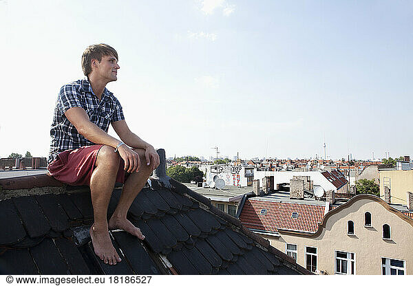 Germany  Berlin  Man sitting on roof