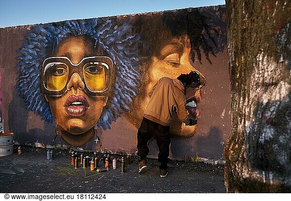 Germany  Berlin  20. 03. 2022  Mauerpark  graffiti wall  graffiti artist Eme Freethinker at work  heads of coloured woman  Europe