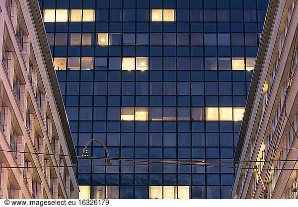 Germany  Berlin-Mitte  illuminated windows of modern office building  old buildings alongside