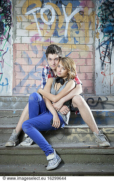 Germany  Berlin  Portrait of teenage couple sitting on stairs