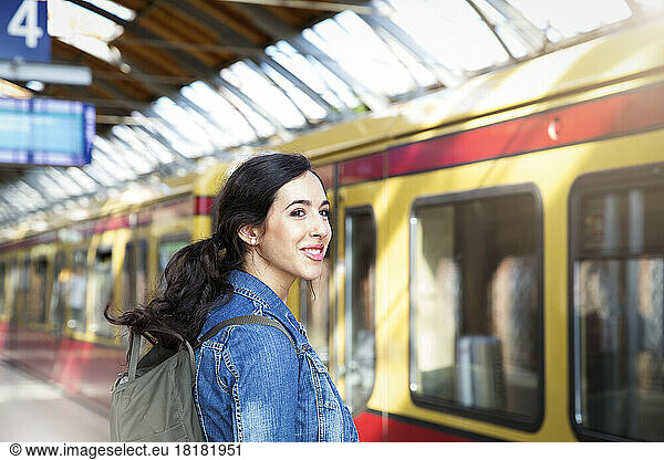 Germany  Berlin  young woman waiting in front of city train