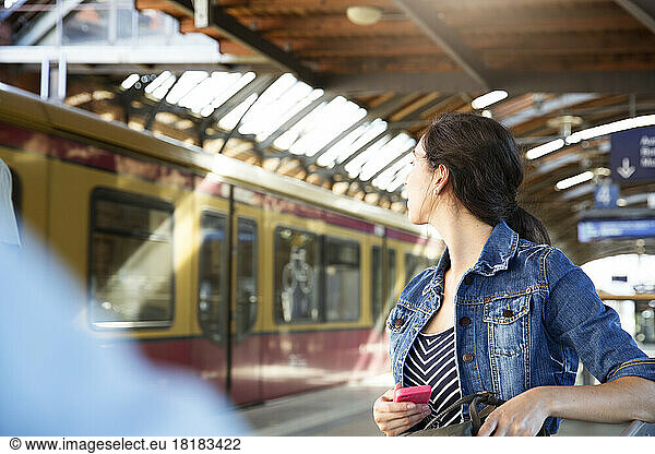 Germany  Berlin  young woman watching city train