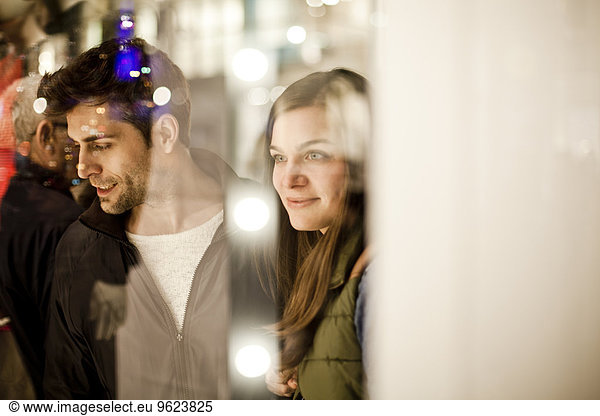 Germany  Cologne  young couple looking at window display