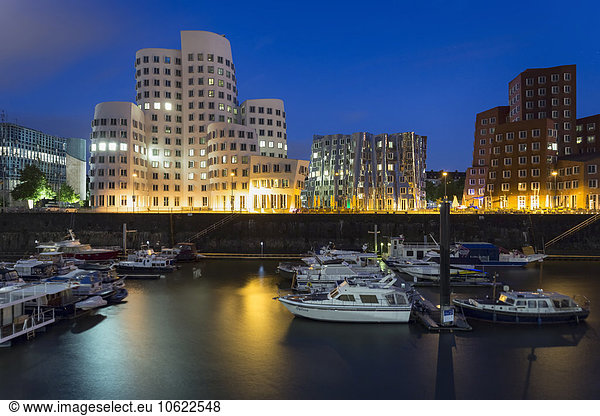 Germany  Duesseldorf  lighted Gehry buildings with harbour in the foreground at twilight