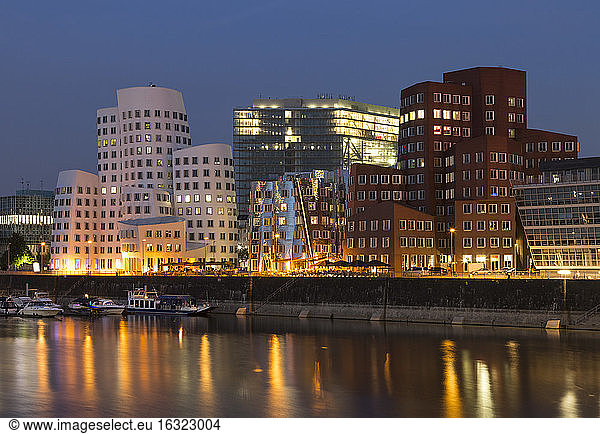 Germany  Duesseldorf  lighted Gehry buildings with Media Harbour in the evening