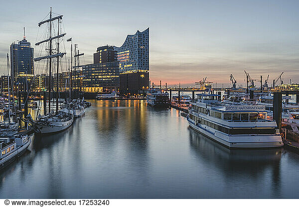 Germany  Hamburg  Boats in harbor and Elbe Philharmonic Hall illuminated at dusk