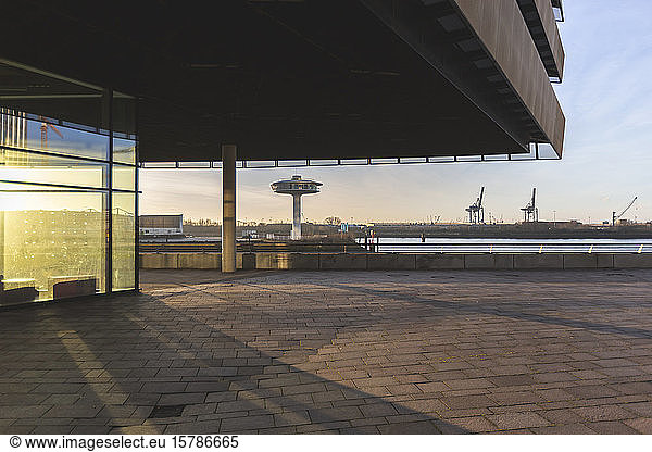 Germany  Hamburg  Canopy over pavement in HafenCity at sunrise with Lighthouse Zero in background