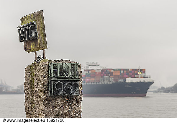Germany  Hamburg  Coastal flood memorial with container ship in background