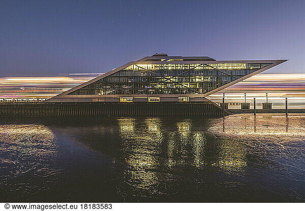 Germany  Hamburg  Dockland ferry terminal at dawn with light trails of passing ship behind