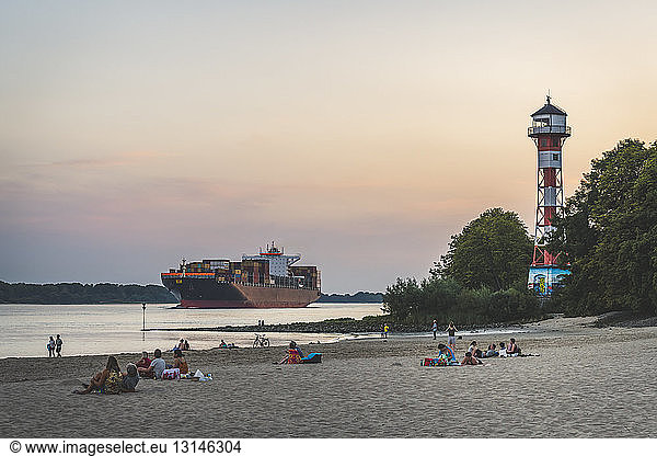 Germany  Hamburg  Hamburg-Rissen  beach and Lighthouse Wittenbergen  Container ship on Elbe river