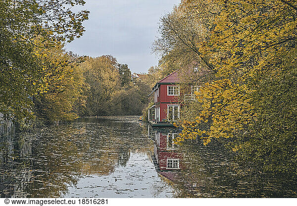 Germany  Hamburg  Isebekkanal in autumn with houseboat in background