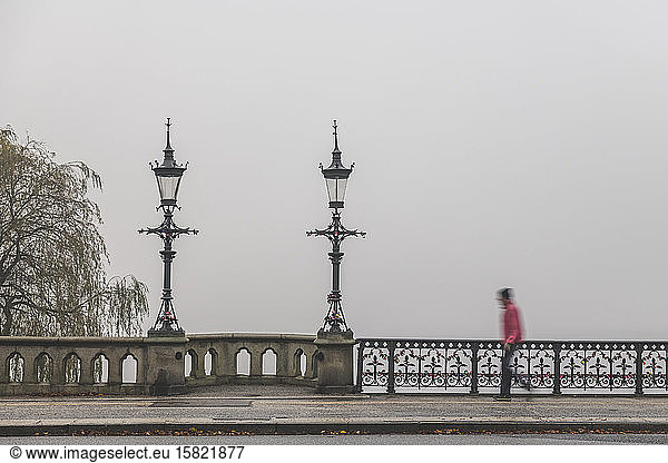 Germany  Hamburg  Pedestrian walking across Schwanenwikbrucke bridge during foggy weather