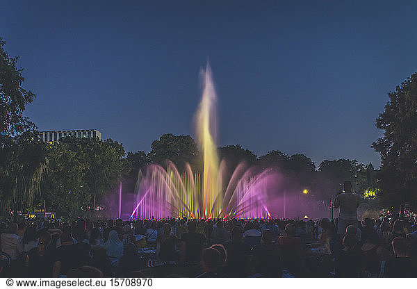 Germany  Hamburg  People watching illuminated fountain at night